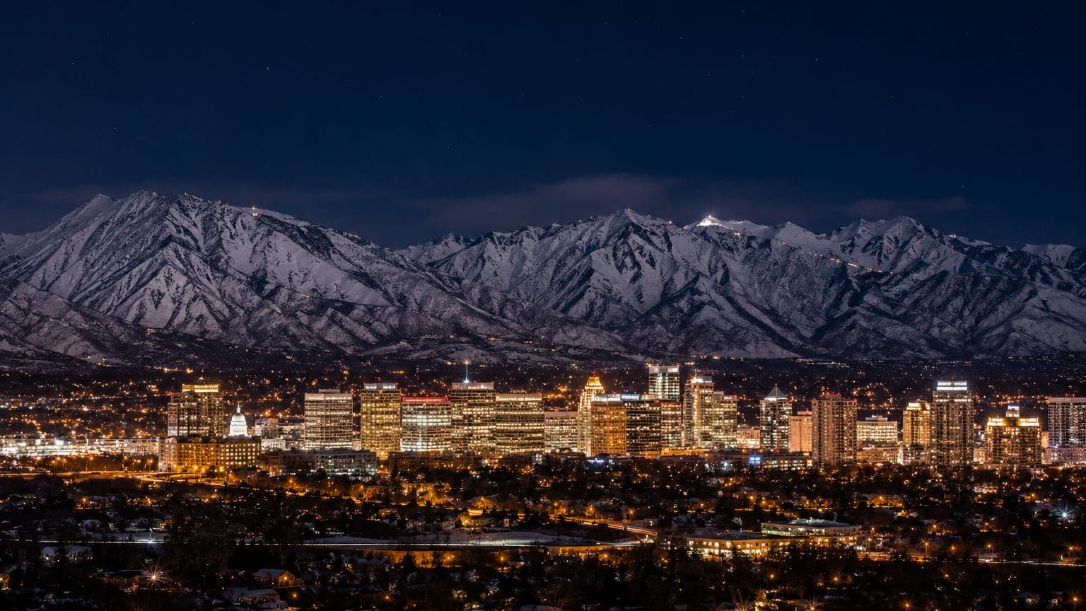 Salt Lake City skyline at night below the Wasatch mountains