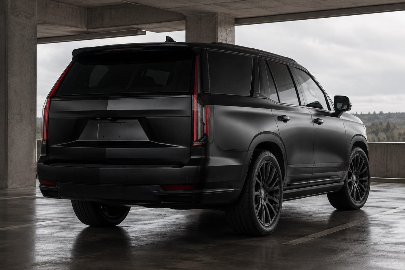 A large black SUV parked in a covered structure, seen from the rear
