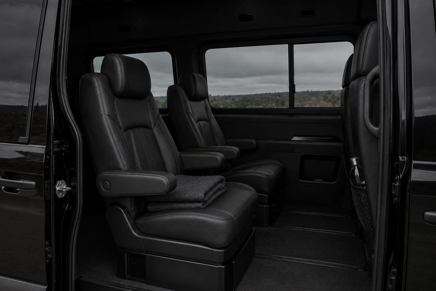 Two leather captain's chairs seen through an open sliding van door